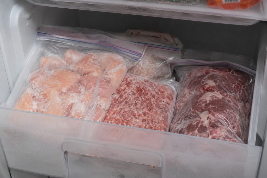 保存袋に入った肉が冷凍庫に入れられている様子